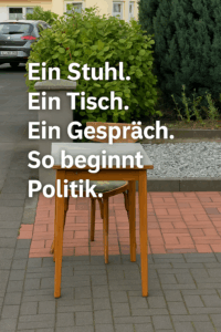 Holztisch mit Stuhl auf einem Gehweg, daneben der Text: „Ein Stuhl. Ein Tisch. Ein Gespräch. So beginnt Politik.“