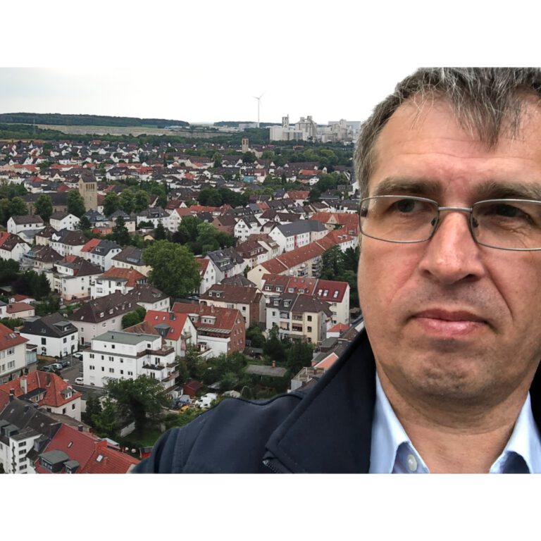 Porträt von Bernd Wroblewski vor der Südstadt Paderborn – mit Blick über die Dächer und der Meinolfskirche im Hintergrund.