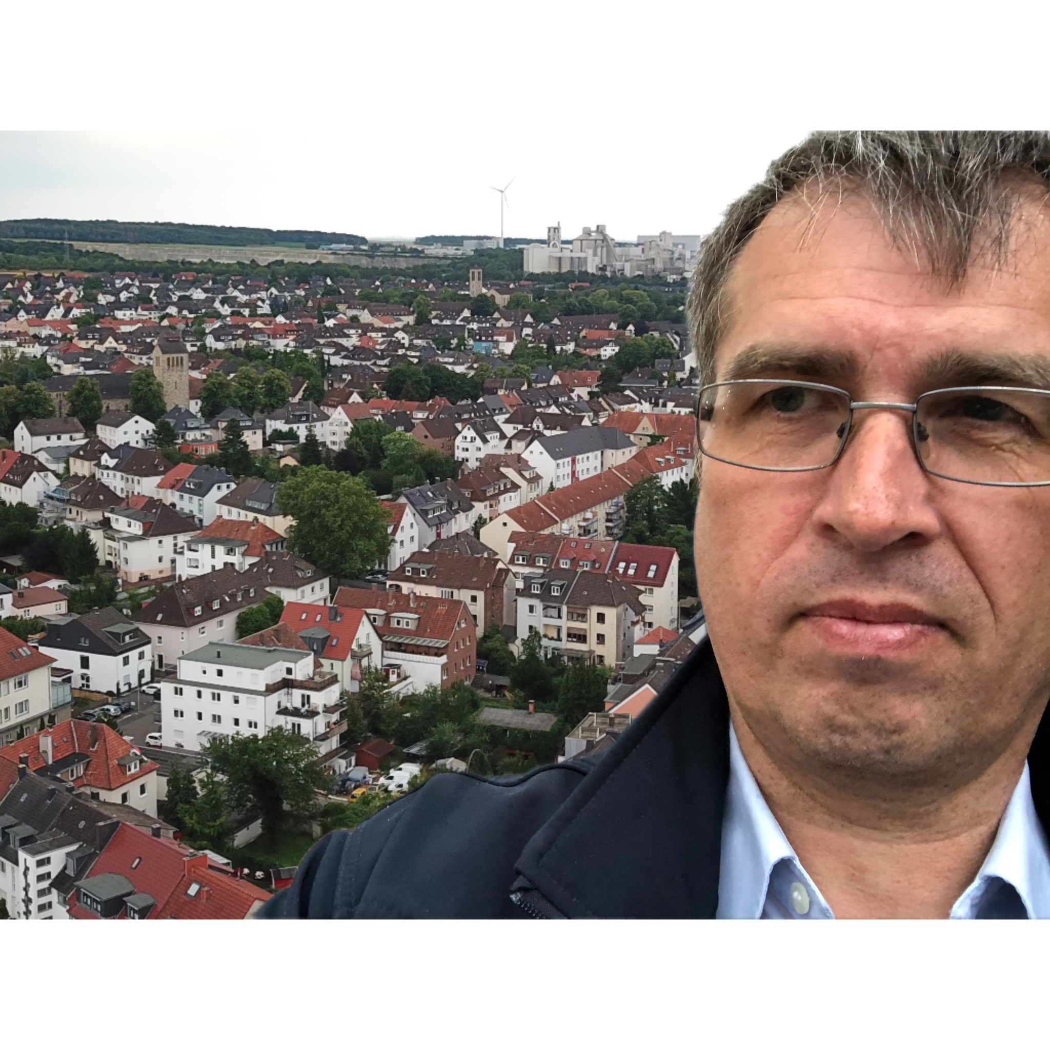 Porträt von Bernd Wroblewski vor der Südstadt Paderborn – mit Blick über die Dächer und der Meinolfskirche im Hintergrund.