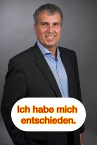 Bernd Wroblewski vor grauem Hintergrund mit dem Statement „Ich habe mich entschieden“ als Bekenntnis zur Kandidatur für den Wahlkreis 9 in der Paderborner Südstadt.
